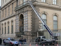 French police officers stand next to a furniture elevator used by robbers to enter the Louvre Museum
