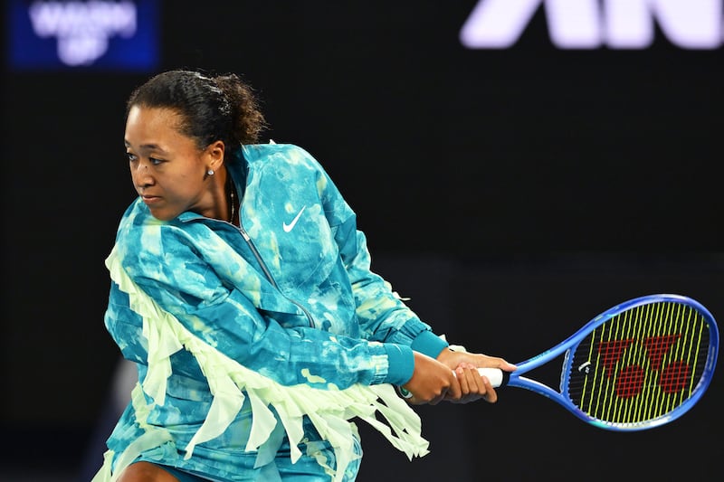 Naomi Osaka wears a ruffled turquoise and green warm-up jacket at the 2026 Australian Open at Melbourne Park on January 20, 2026.