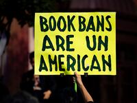A person participates in a protest against Moms for Liberty.