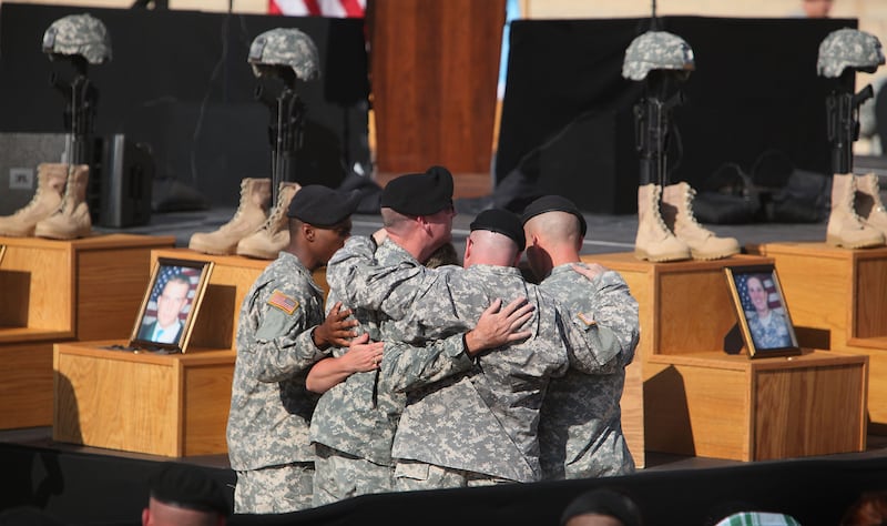U.S. Army soldiers grieve together during the memorial service in honor of the thirteen victims of the shooting rampage on November 10, 2009, in Fort Hood, Texas.