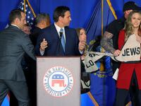 Protesters are taken away by security during Ron DeSantis’ on-stage speech.