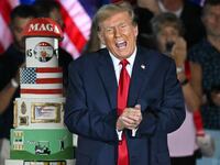 Donald Trump gestures by his birthday cake in 2024.