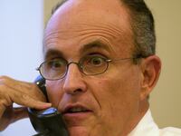Former Mayor Rudy Giuliani chats on the phone at Times Square offices of his consulting firm, Giuliani Partners.