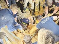 Rescue workers from numerous agencies work to dig out Jacksonville resident Andrew Giddens from quicksand at a Melrose borrow pit.
