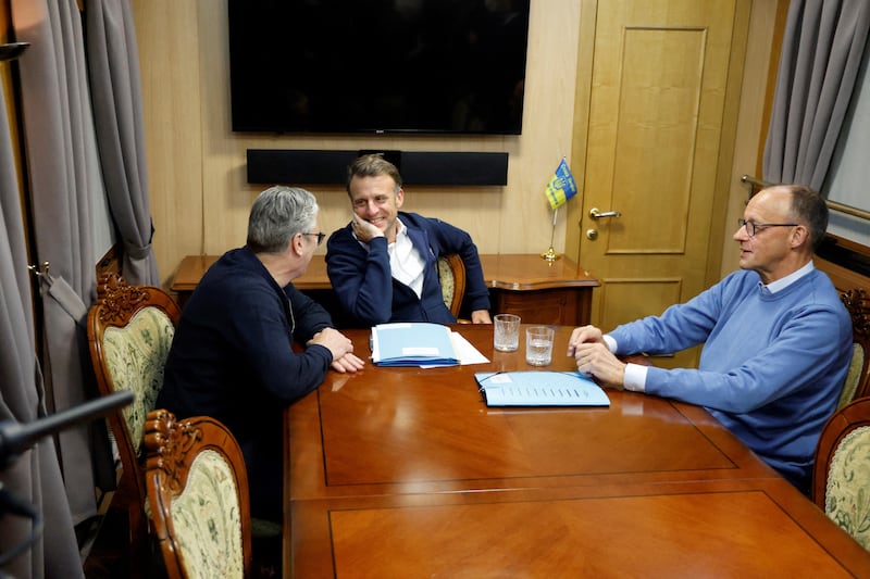 France's President Emmanuel Macron (C), Britain's Prime Minister Keir Starmer (L) and German Chancellor Friedrich Merz (R) hold a trilateral meeting on board a train to Kyiv, in Shegyni, Ukraine, on May 9, 2025.