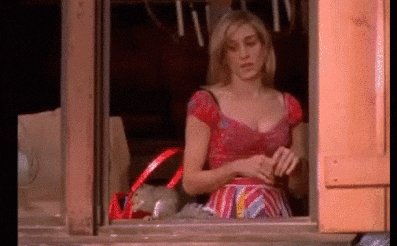 Gif: Carrie Bradshaw sees squirrel outside the window and screams and runs away.