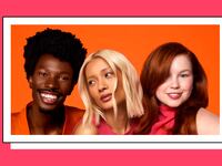 Three people posing on an orange background. The first person has dark black hair, the second has blonde hair, and the third has red hair.