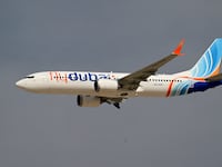 A Flydubai Boeing 737 MAX 8 performs a display flight at Al-Maktoum International Airport during the Dubai Airshow 2025 in Dubai on November 17, 2025.