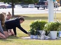 Students kneel in front of a makeshift memorial in front of Apalachee High School on September 5, 2024 in Winder, Georgia.