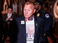 Rep. Troy Nehls walks to the House Chamber wearing a Donald Trump shirt and a Laken Riley pin ahead of the President's State of the Union address