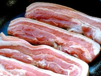 A panful of uncooked bacon.