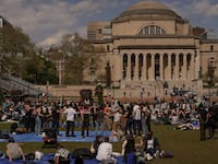 Protesters lead a demonstration on the campus of Columbia University during the daytime.