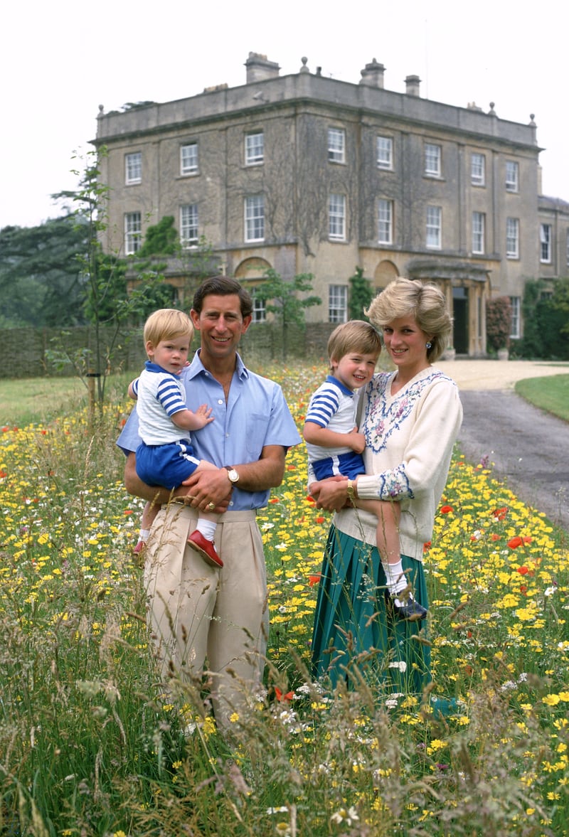 A photo of Prince Charles and Princess Diana with their sons in a field