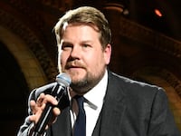 James Corden on stage with microphone
