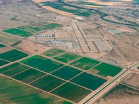 Aerial view of farmlands in Avra Valley south of Avra Valley Rd. and the Central Arizona Project, CAP, canal with Marana Regional Airport in the background.