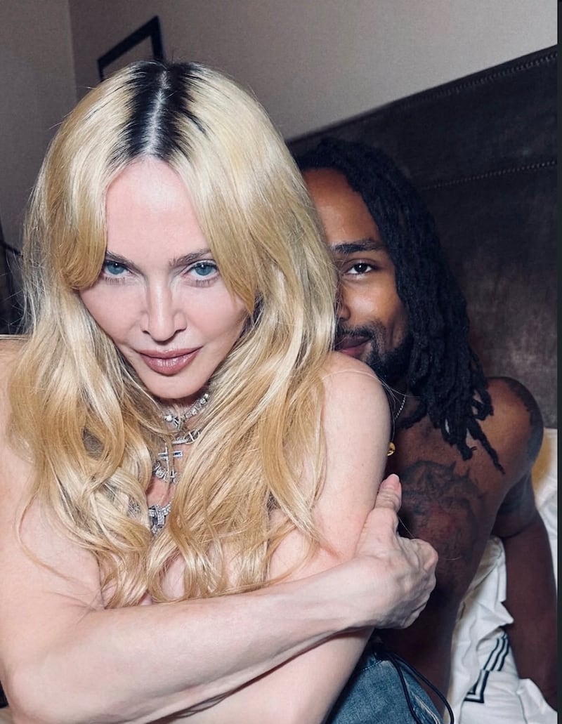 Madonna posing on a bed topless with her 29-year-old boyfriend, Akeem Morris