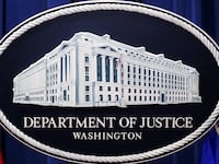 The Department of Justice logo as a backdrop for a press conference.