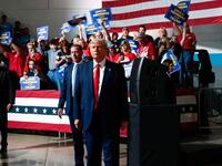 Former U.S. President and Republican presidential candidate Donald Trump looks on while his supporters cheer on the day he addresses auto workers as he skips the second GOP debate, in Clinton Township, Michigan