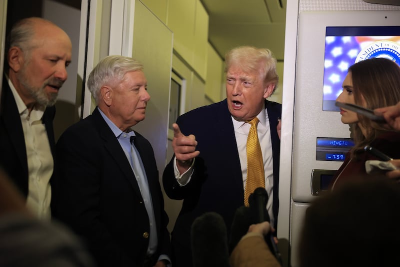 IN FLIGHT - JANUARY 04: U.S. President Donald Trump, Commerce Secretary Howard Lutnick (L) and U.S. Sen. Lindsey Graham (R-SC) (C) speak to the media aboard Air Force One enroute to Washington, DC on January 04, 2026. Trump is returning to the White House after giving the order for the United States law enforcement to capture Venezuelan President Nicolás Maduro and his wife. (Photo by Joe Raedle/Getty Images)