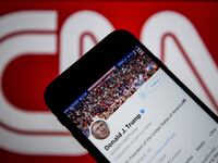 Donald Trump's Twitter timeline is seen on a smartphone against a backdrop with the CNN TV channel logo.