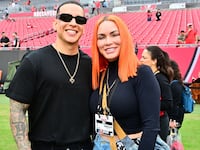 Recording artist Daddy Yankee and his wife Mireddys González pose for a photo on the field before the game between the Tampa Bay Buccaneers and the Carolina Panthers at Raymond James Stadium on January 01, 2023 in Tampa, Florida.