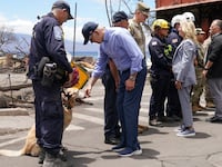 U.S. President Joe Biden and first lady Jill Biden meet first responders and a rescue dog in the fire-ravaged town of Lahaina on the island of Maui in Hawaii, U.S., August 21, 2023.