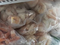 Frozen shrimp sit in a freezer at a seafood bistro in the harbor.
