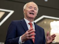 Asa Hutchinson speaks on stage at an event.