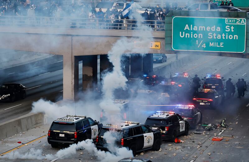 California Highway Patrol (CHP) cars, some damaged, are lined up along the 101 freeway after officers cleared protesters from the area.