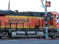 NATIONAL CITY, CALIFORNIA - APRIL 26: A BNSF Railway locomotive and train travels through an intersection at the National City Marine Terminal on April 26, 2025 in National City, California.