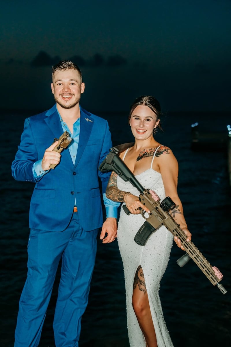 Bella and Kyle Rittenhouse holding guns at their wedding.