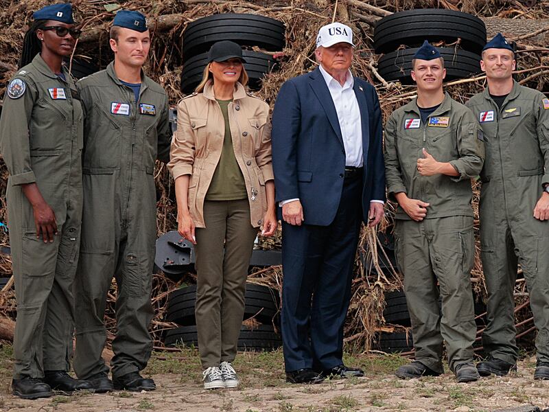 President Donald Trump and first lady Melania Trump pose for pictures with local emergency services personnel in front of a mobile concert stage in Louise Hays Park that was destroyed during flash flooding along the Guadalupe River on July 11, 2025 in Kerrville, Texas.