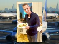 Sean Duffy in a kitchen in front of a white countertop and white wooden cabinets holding a plate with two tacos and a background of United planes at Newark international airport.