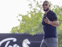 Andrew Tate gestures towards the media before delivering a press statement outside his house in Voluntari, Ilfov, Romania, August 4, 2023.