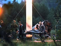 Emergency specialists carry a body bag near wreckage of the private jet linked to Wagner mercenary chief Yevgeny Prigozhin at the crash site in the Tver region, Russia, Aug. 24, 2023.