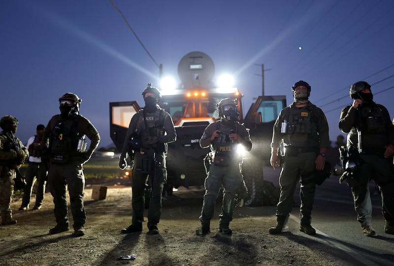 CAMARILLO, CALIFORNIA - JULY 10: Federal agents block people protesting an ICE immigration raid at a nearby licensed cannabis farm on July 10, 2025 near Camarillo, California. Protestors stood off with federal agents for hours outside the farm in the farmworker community in Ventura County. A Los Angeles federal judge is set to rule Friday on a temporary restraining order which would restrict area immigration enforcement operations. (Photo by Mario Tama/Getty Images)