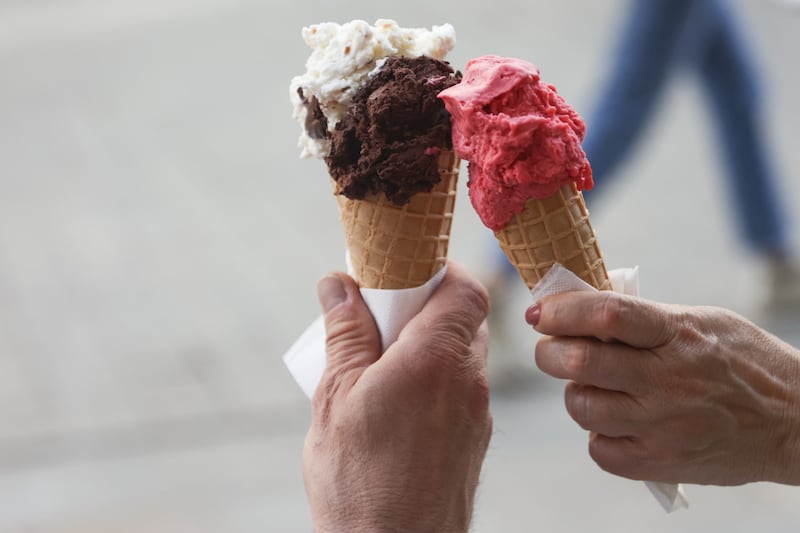 Two gelato ice cream cones touching.