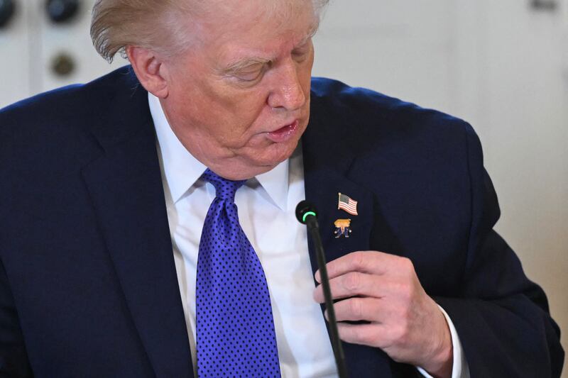 US President Donald Trump shows a lapel pin as he speaks during a meeting with US oil companies executives in the East Room of the White House in Washington, DC on January 9, 2026. President Trump is aiming to convince oil executives to support his plans in Venezuela, a country whose energy resources he says he expects to control for years to come. US forces seized Venezuelan president Nicolas Maduro in a sweeping military operation on January 3, with Trump making no secret that control of Venezuela's oil was at the heart of his actions. (Photo by SAUL LOEB / AFP via Getty Images)