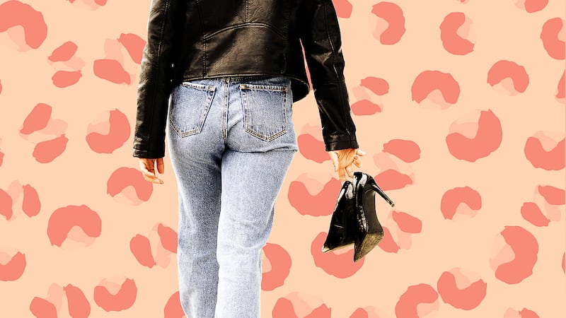 Woman in jacket holding shoes.