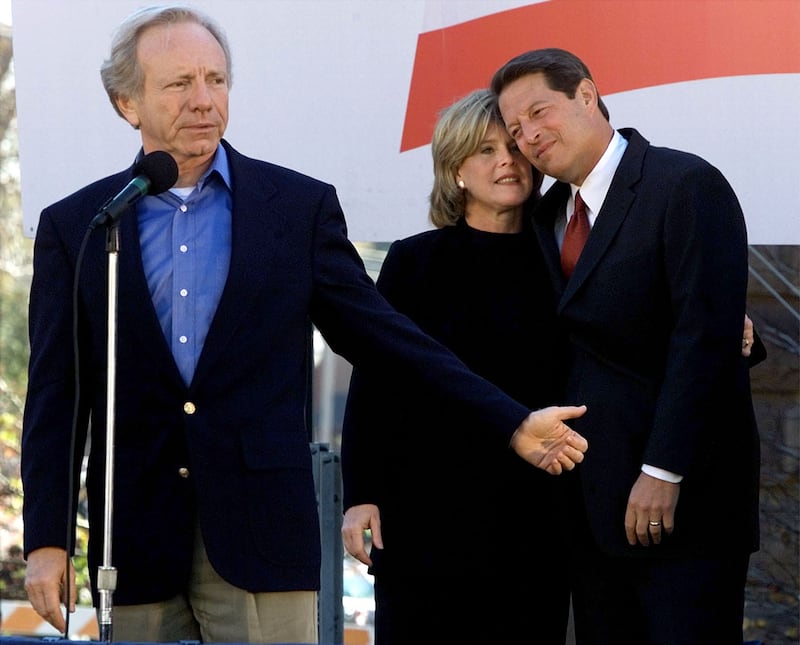 Then-Democratic presidential nominee Al Gore hugs his wife, Tipper, as his running mate, Sen. Joe Lieberman, speaks at a 2000 campaign rally in Green Bay, Wisconsin.