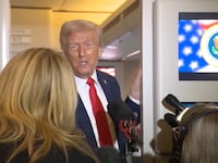 Trump addresses reporters aboard Air Force One.