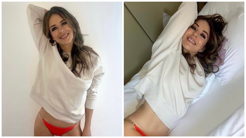 Elizabeth Hurley wearing a white sweatshirt and red bikini bottom