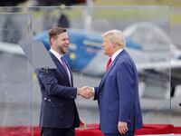 Republican presidential nominee Donald Trump and his vice presidential nominee JD Vance shake hands in a bulletproof 'glass house' during a rally in Asheboro, North Carolina on August 21, 2024.