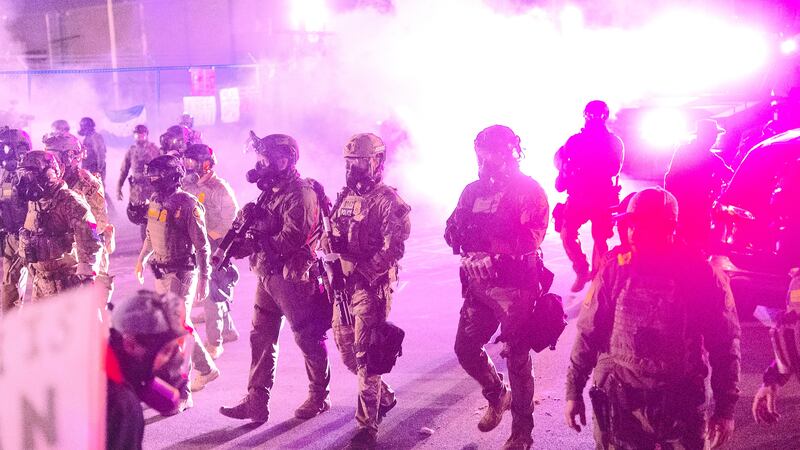 Federal law enforcement agents attack demonstrators protesting outside of an immigrant processing center with a barrage of tear gas and pepper balls