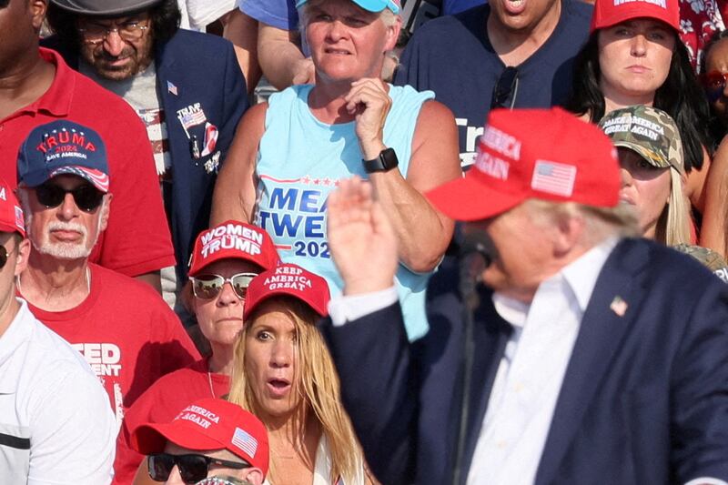 Trump gesticulates towards his ear