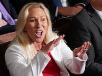 Marjorie Taylor Greene (R-GA) yells out at House Minority Leader Hakeem Jeffries (D-NY) as Jeffries introduces newly elected Speaker of the House Mike Johnson