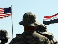 US troops stand to attention in front of American and Iraqi (R) flags during a handover ceremony near the northern Iraqi town of Hawija where the US military formally transferred Contingency Operating Location McHenry to Iraqi security forces on May 15, 2011. COL McHenry, just outside of Hawija and north of Baghdad in the disputed ethnically-mixed province of Kirkuk, was one of a handful of bases the US military maintained in Kirkuk and is considered the oldest American base in Iraq, having been established shortly after the 2003 invasion that ousted Saddam Hussein. AFP PHOTO / ALI AL-SAADI (Photo by ALI AL-SAADI / AFP) (Photo by ALI AL-SAADI/AFP via Getty Images)