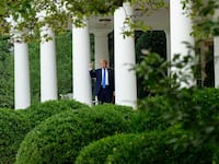 President Donald Trump tests the speakers of the newly renovated Rose Garden.