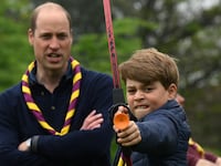 Britain's Prince George of Wales tries his hand at archery as Britain's Prince William, Prince of Wales, watches him, while taking part in the Big Help Out, during a visit to the 3rd Upton Scouts Hut in Slough, west of London, Britain, May 8, 2023.
