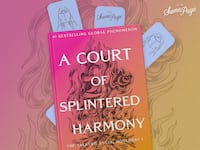 “A Court of Splintered Harmony” (The Valkyrie Cycle: Movement I) with a pink-orange flame-illustrated cover, tucked among three blue On The Same Page bookmarks on a pink-gold background.